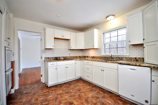 a kitchen with granite countertop cabinets sink and window