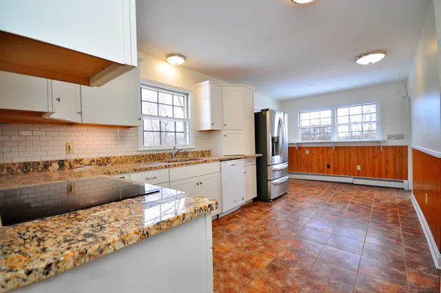 a kitchen with stainless steel appliances granite countertop a stove a sink and a refrigerator