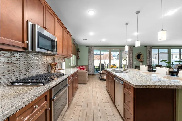 a kitchen with stainless steel appliances granite countertop a sink stove and refrigerator
