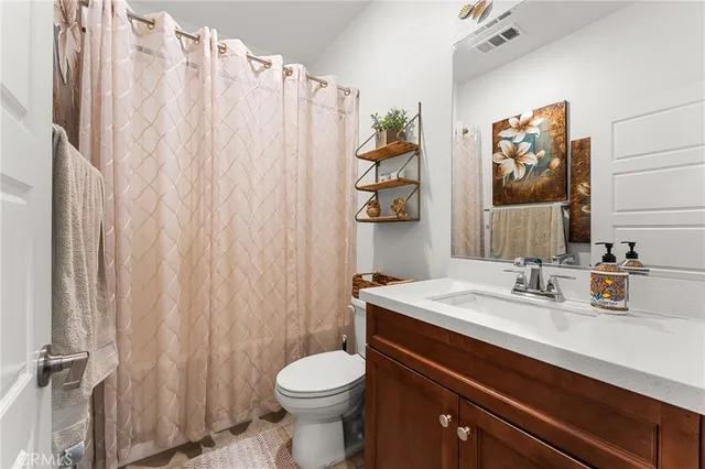 a bathroom with a sink a toilet and shower curtain