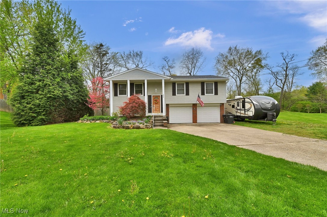 7676 Brecksville Road Independence, OH 44131 - Photo 28 of 32 Split foyer home featuring brick siding, a garage, a front lawn, and concrete driveway