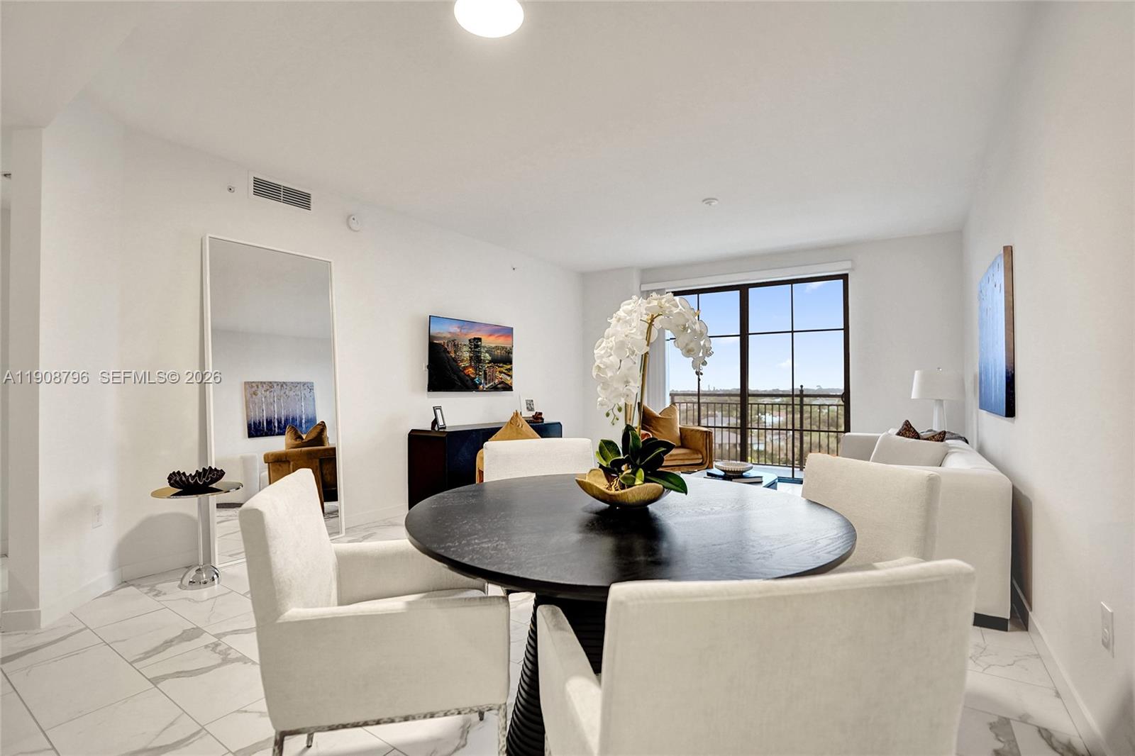 101 East Camino Real, Unit 1025 Boca Raton, FL 33432 - Photo 4 of 12 a view of a dining room and livingroom with furniture wooden floor and a rug