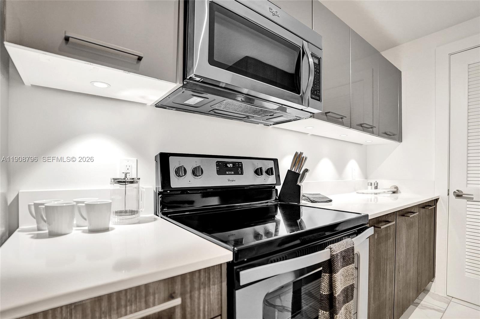 101 East Camino Real, Unit 1025 Boca Raton, FL 33432 - Photo 6 of 12 a kitchen with a stove and a microwave