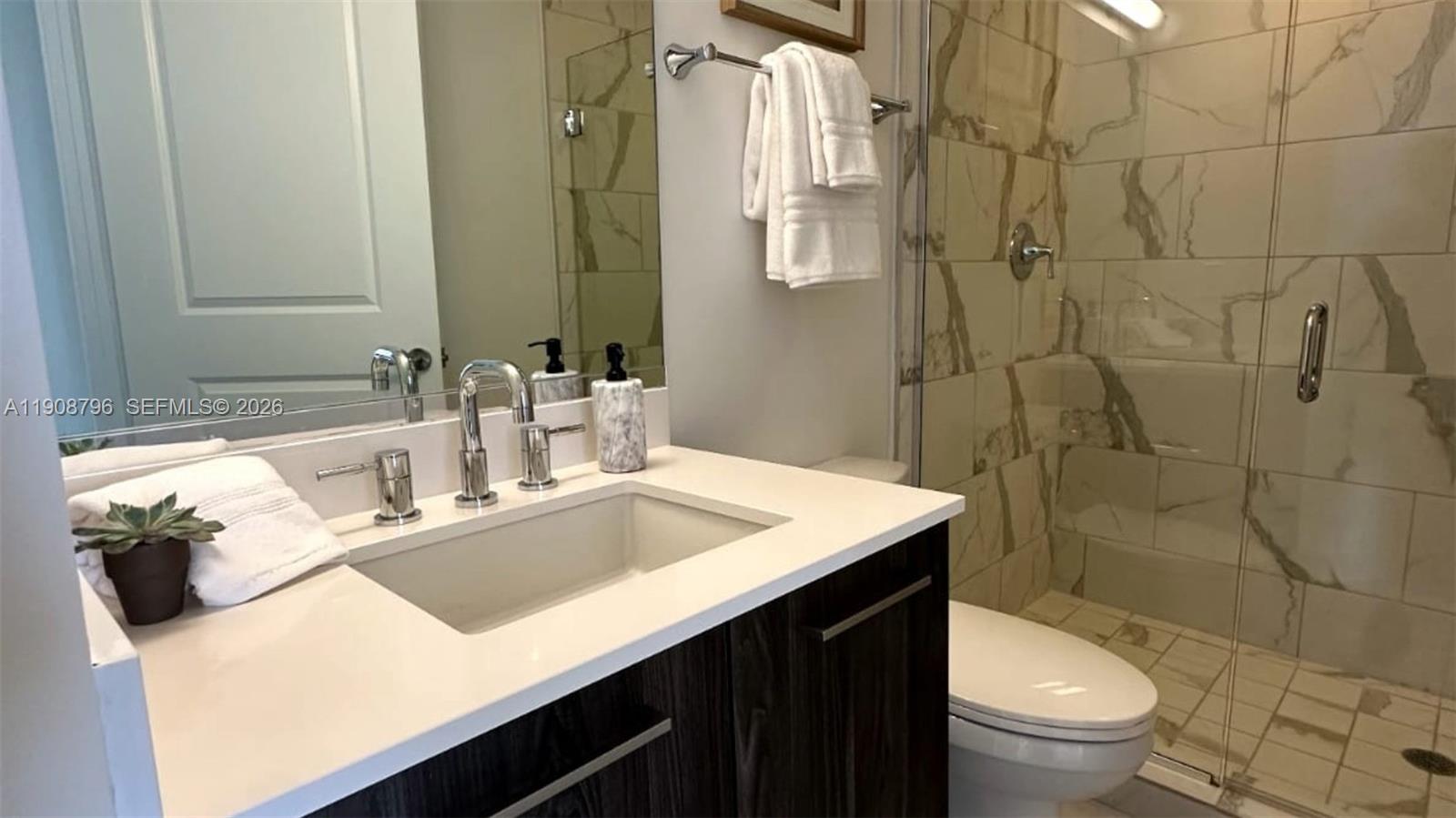 101 East Camino Real, Unit 1025 Boca Raton, FL 33432 - Photo 9 of 12 a bathroom with a sink toilet and shower