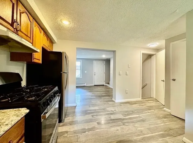 a kitchen with stainless steel appliances kitchen island granite countertop a stove and a refrigerator