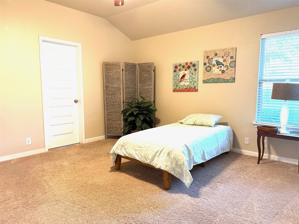 227 Avalanche Avenue Georgetown, TX 78626 - Photo 26 of 27 a bedroom with a bed lamp and a large window