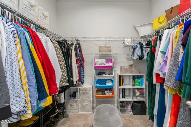 a view of walk in closet with clothes and shoes