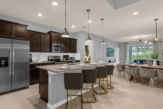 a kitchen with kitchen island a dining table chairs sink and microwave