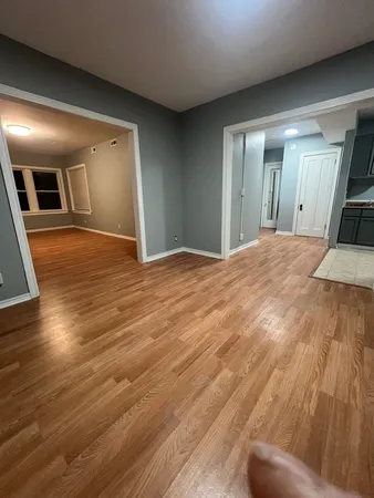 a view of empty room with wooden floor