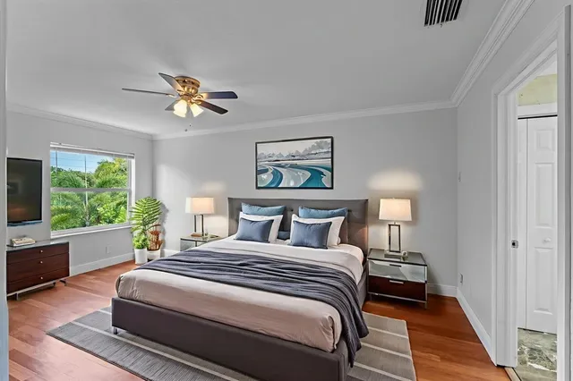 a bedroom with a large bed a chandelier and a window