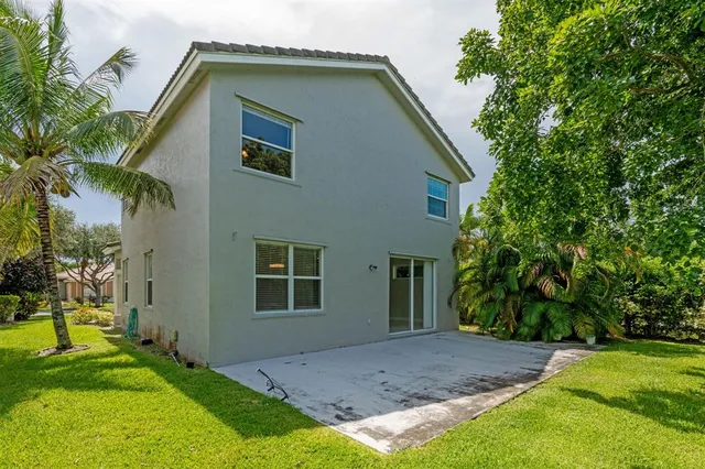a house that has a big yard plants and large trees