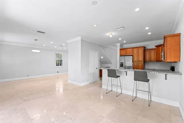 a large kitchen with stainless steel appliances kitchen island granite countertop a table and chairs