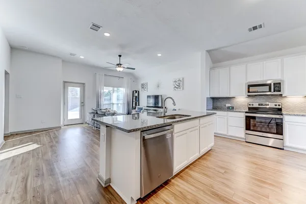 a kitchen with granite countertop a sink and steel appliances