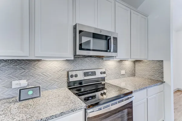 a kitchen with appliances a sink and cabinets