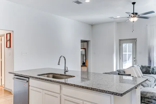a kitchen with granite countertop a sink stainless steel appliances and a counter space