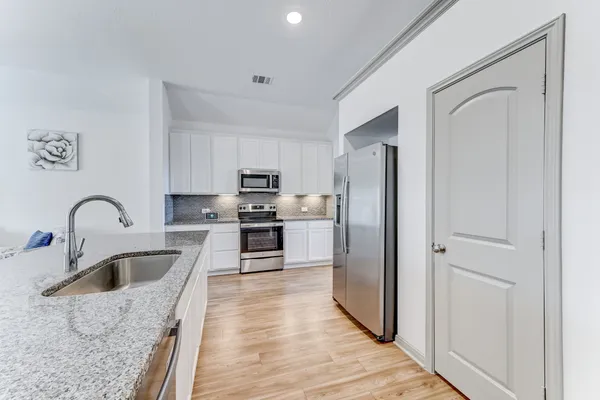 a kitchen with stainless steel appliances granite countertop a refrigerator sink and stove