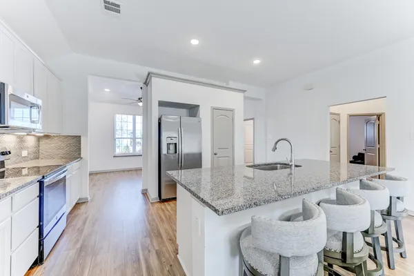 a kitchen with granite countertop kitchen island a table and chairs in it