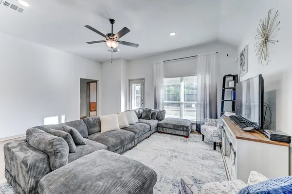 a living room with furniture ceiling fan and a window