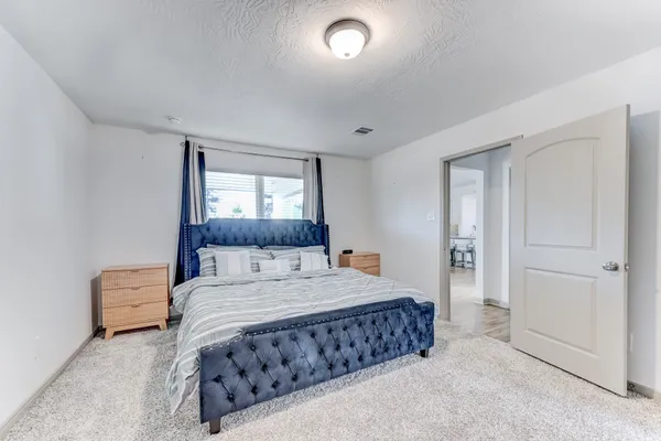 a bedroom with a bed and a night stand