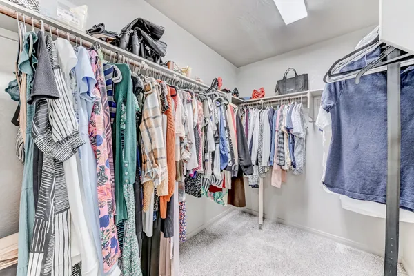 a view of walk in closet with clothes