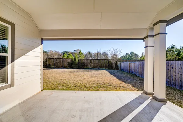 a view of backyard with wooden fence