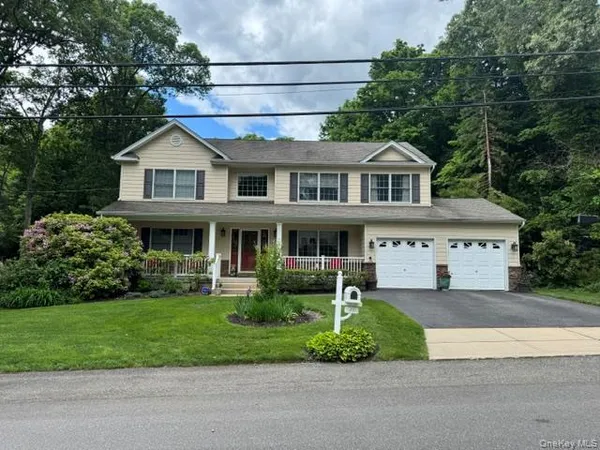 a front view of a house with a yard and potted plants