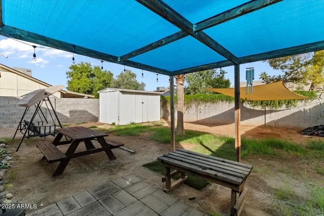 a view of chairs and table in backyard