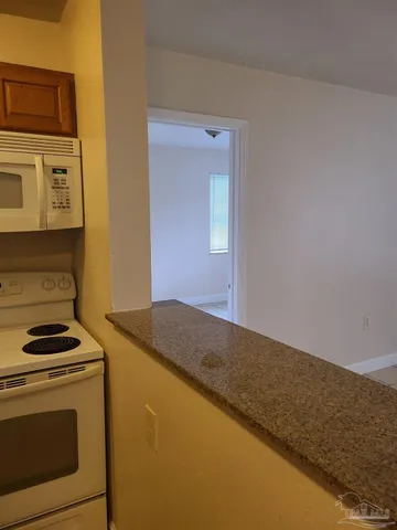 a kitchen with granite countertop cabinets stainless steel appliances and a counter space