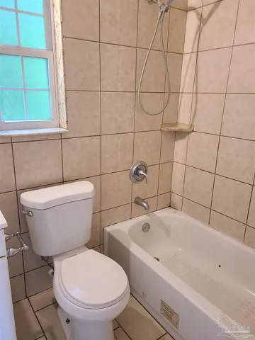 a white bath tub sitting next to a white toilet