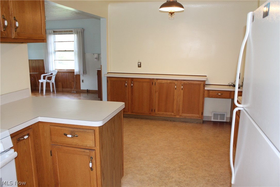 14863 Turney Road Maple Heights, OH 44137 - Photo 6 of 34 Kitchen with white appliances, kitchen peninsula, and light tile floors