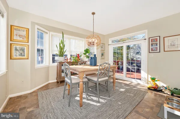 a dining room with furniture a chandelier and wooden floor