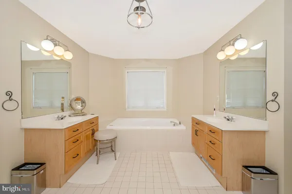 a spacious bathroom with a double vanity sink a mirror and a bathtub