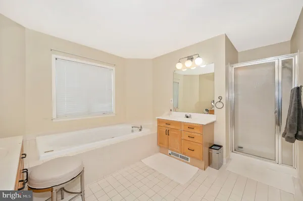 a spacious bathroom with a tub sink and mirror