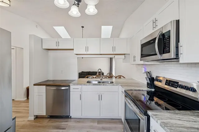 a kitchen with stainless steel appliances a stove a sink and a microwave