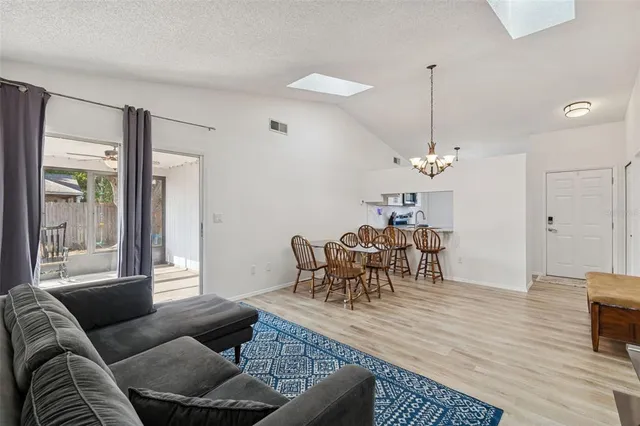 a dining room with furniture a chandelier and window