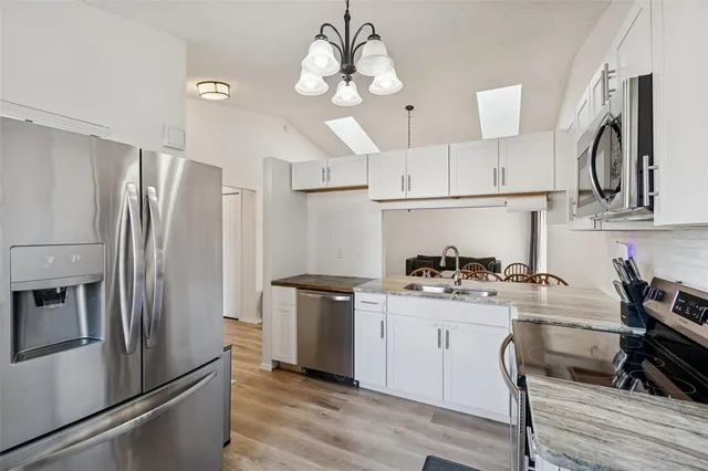 a kitchen with stainless steel appliances a sink stove and refrigerator