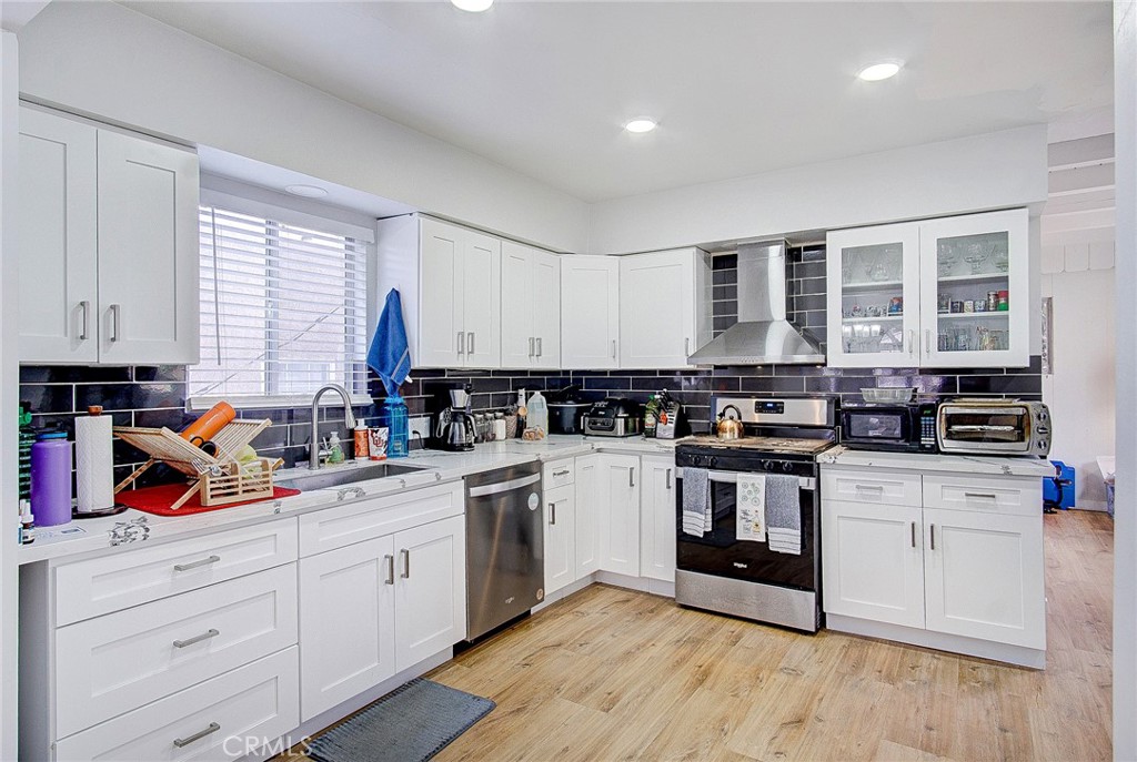 701 Westminster Avenue Alhambra, CA 91803 - Photo 11 of 35 a kitchen with stainless steel appliances granite countertop a stove and white cabinets