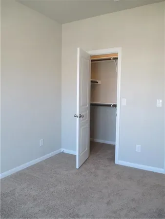 an empty room with closet and a window