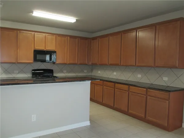 a kitchen with granite countertop wood cabinets stainless steel appliances and a sink