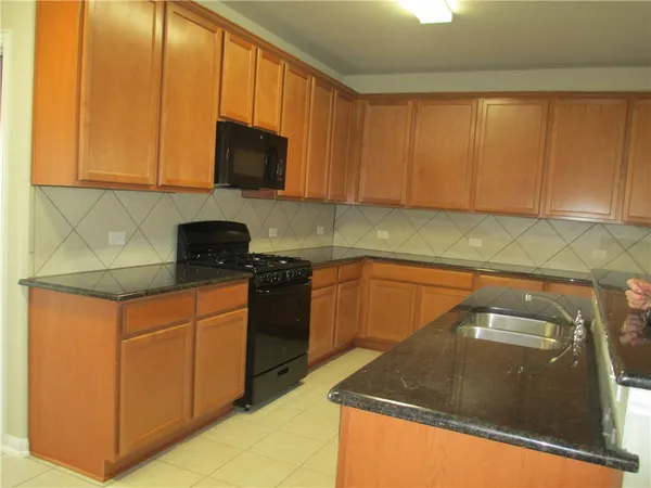 a kitchen with granite countertop cabinets and black stainless steel appliances