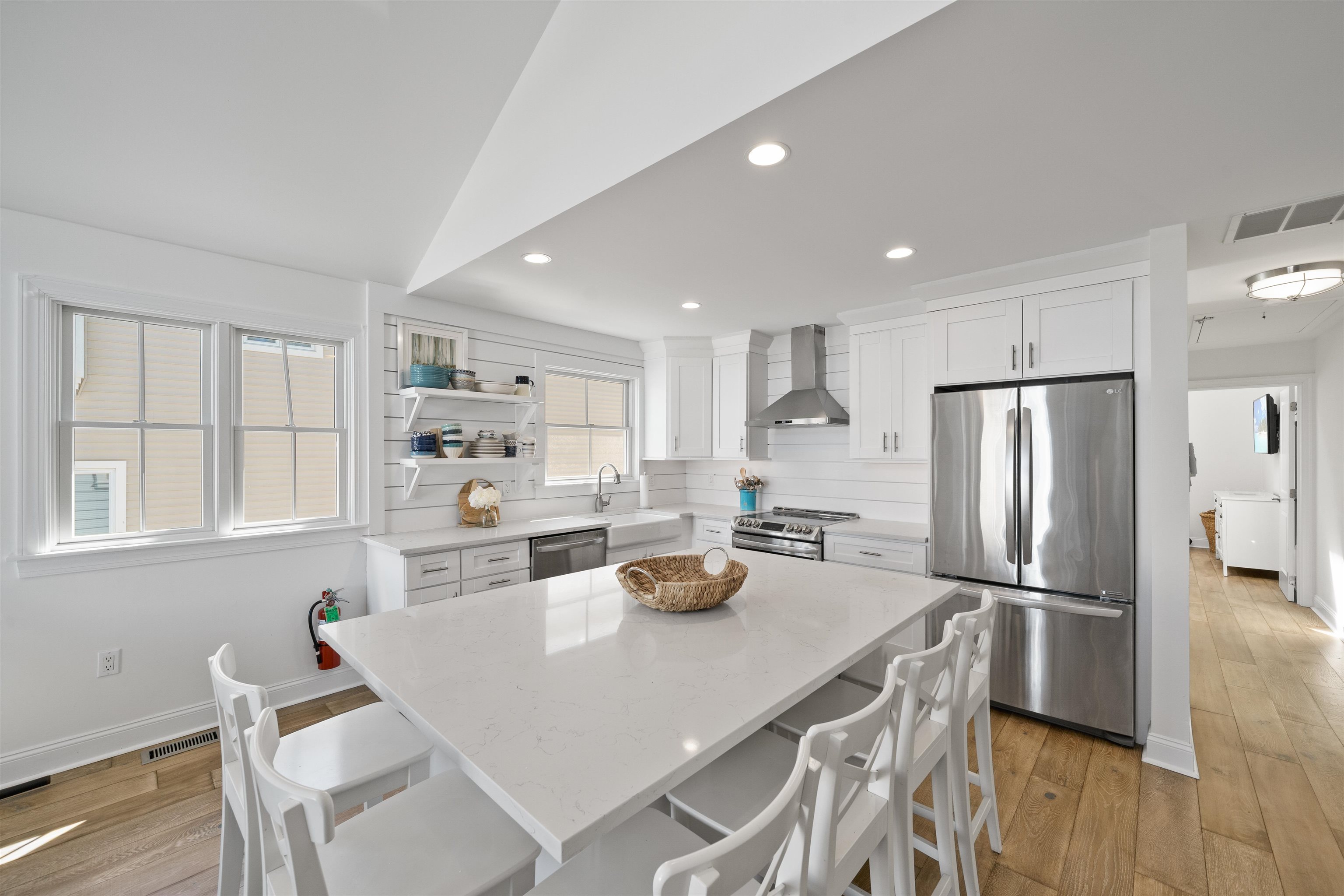 360 39th Street, Unit EAST Avalon, NJ 08202 - Photo 6 of 28 a kitchen with stainless steel appliances granite countertop a refrigerator a stove a sink a dining table and chairs