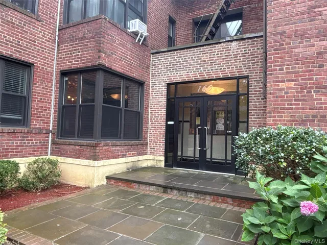 a view of a brick building with potted plants in front of door