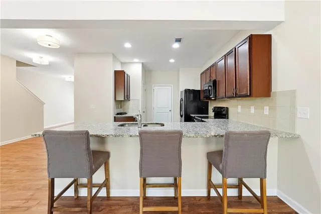 a kitchen with a dining table chairs and wooden floor