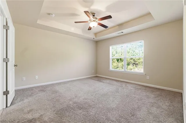 an empty room with fan and windows