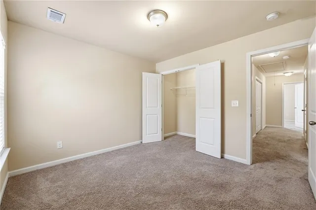 an empty room with closet and a bathroom