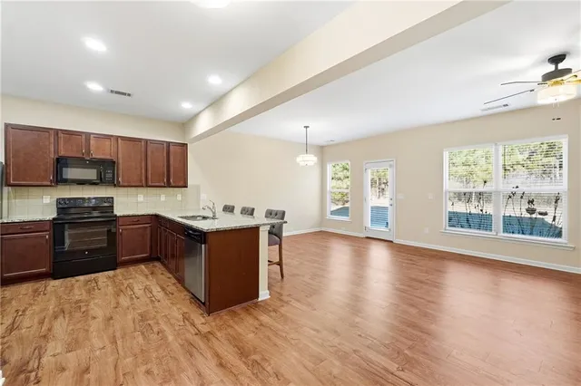 a large kitchen with wooden floors and stainless steel appliances