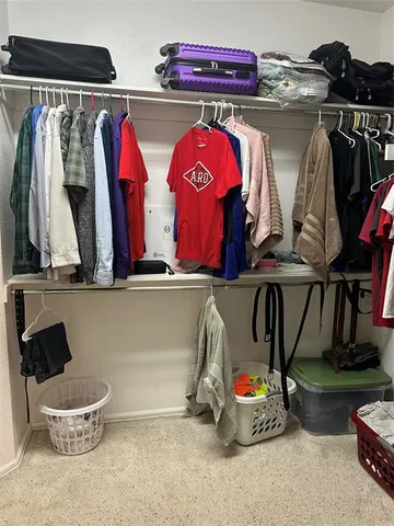 a view of walk in closet with clothes and shoes