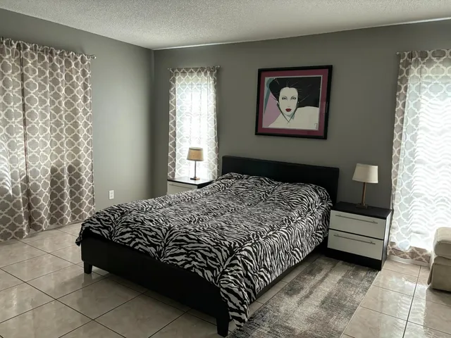 a bedroom with a bed and a painting on the wall