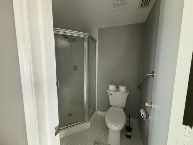 a bathroom with a toilet and a shower