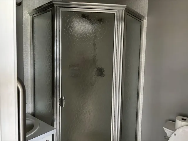 a bathroom with a glass shower door and a mirror